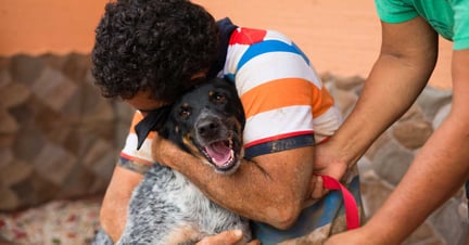 Man holds pet dog in aftermath of Hurricane Otto