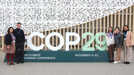 The 2024 delegates stand around the COP29 entry sign in Baku, Azerbaijan. Pictured left-right, Kelly Dent, Tricia Croasdell, Elodie Guillon, Shuang (Serena) An, Angel Flores.